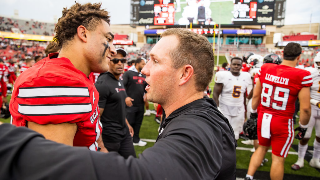 Jalin Conyers #12 of the Texas Tech Red Raiders embraces Kenny Dillingham of the Arizona State Sun ...