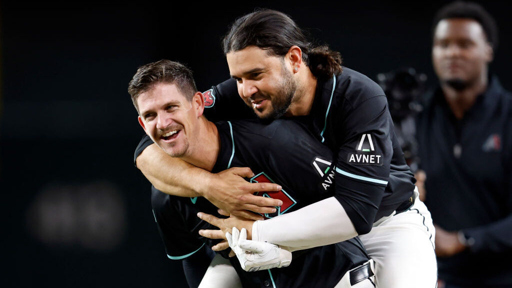 Arizona Diamondbacks teammates Kevin Newman and Eugenio Suarez embrace...