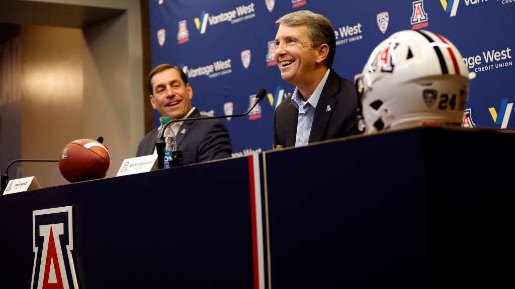 Athletic director Dave Heeke looks on as new head coach Brent Brennan of the Arizona Wildcats answe...
