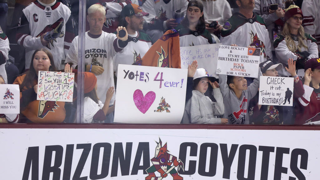 Fans hold up signs before the NHL game between the Edmonton Oilers and the Arizona Coyotes at Mulle...