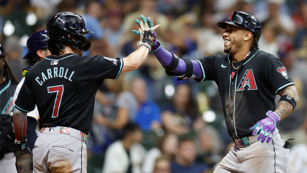Ketel Marte #4 of the Arizona Diamondbacks is congratulated crossing home plate by Corbin Carroll #...