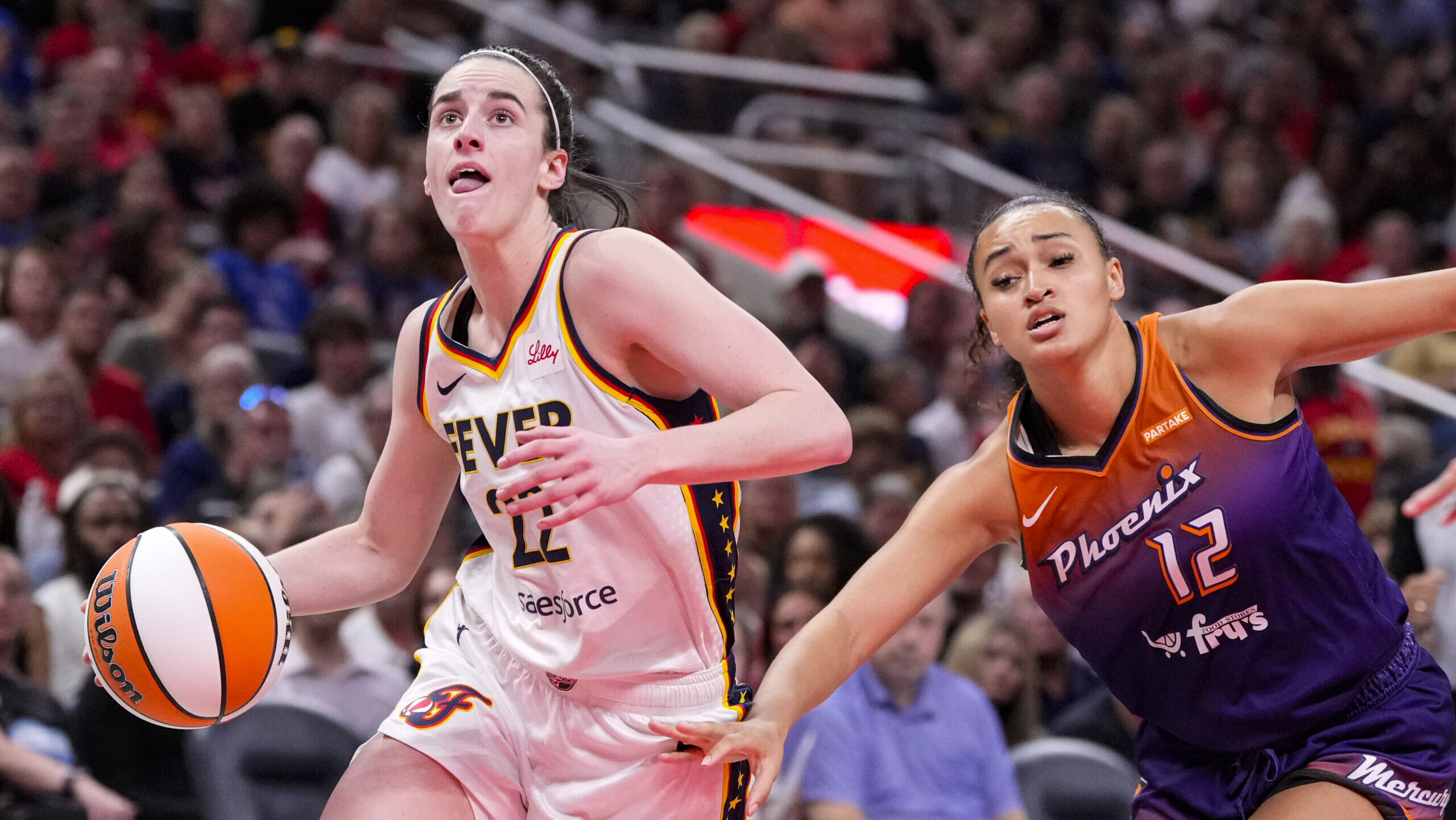 Caitlin Clark drives by Mercury guard Celeste Taylor...