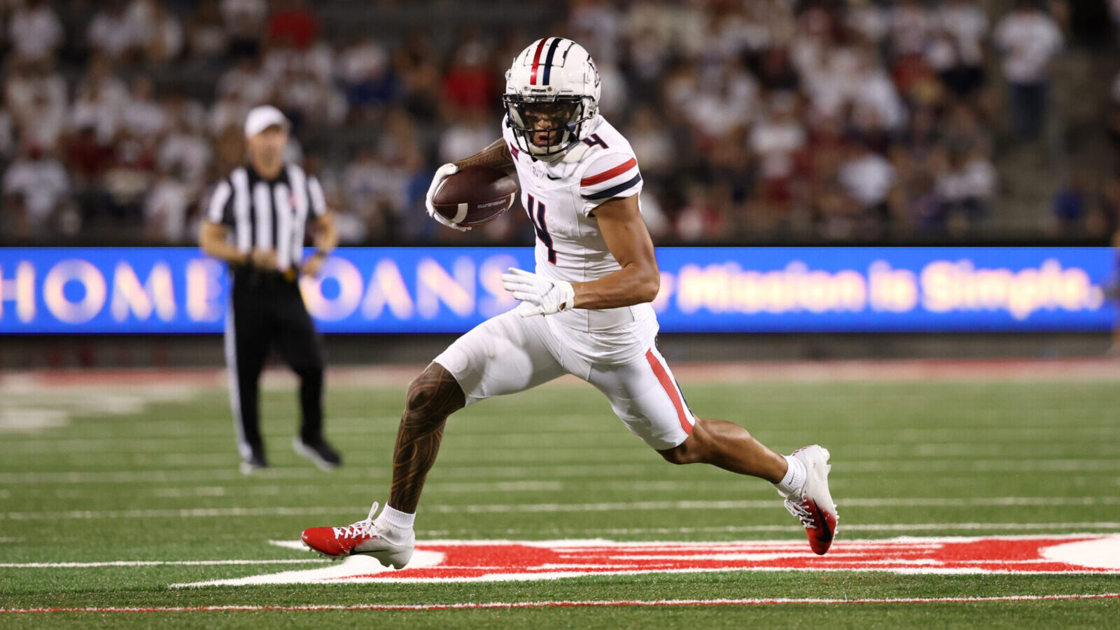 Arizona football's Tetairoa McMillan in stride with the ball in hand...